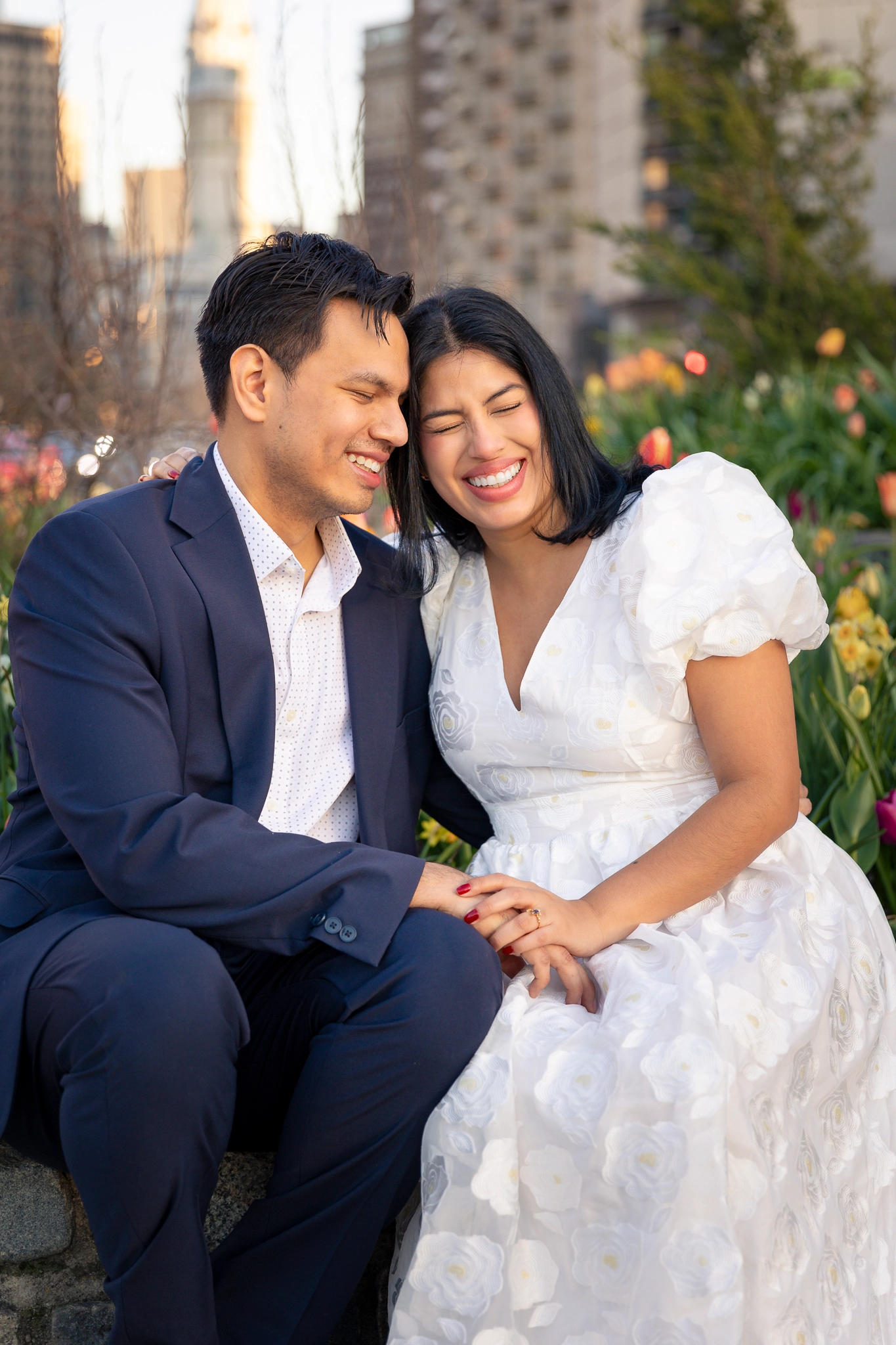 A happy couple laughing during an engagement session at Logan Square in Philadelphia