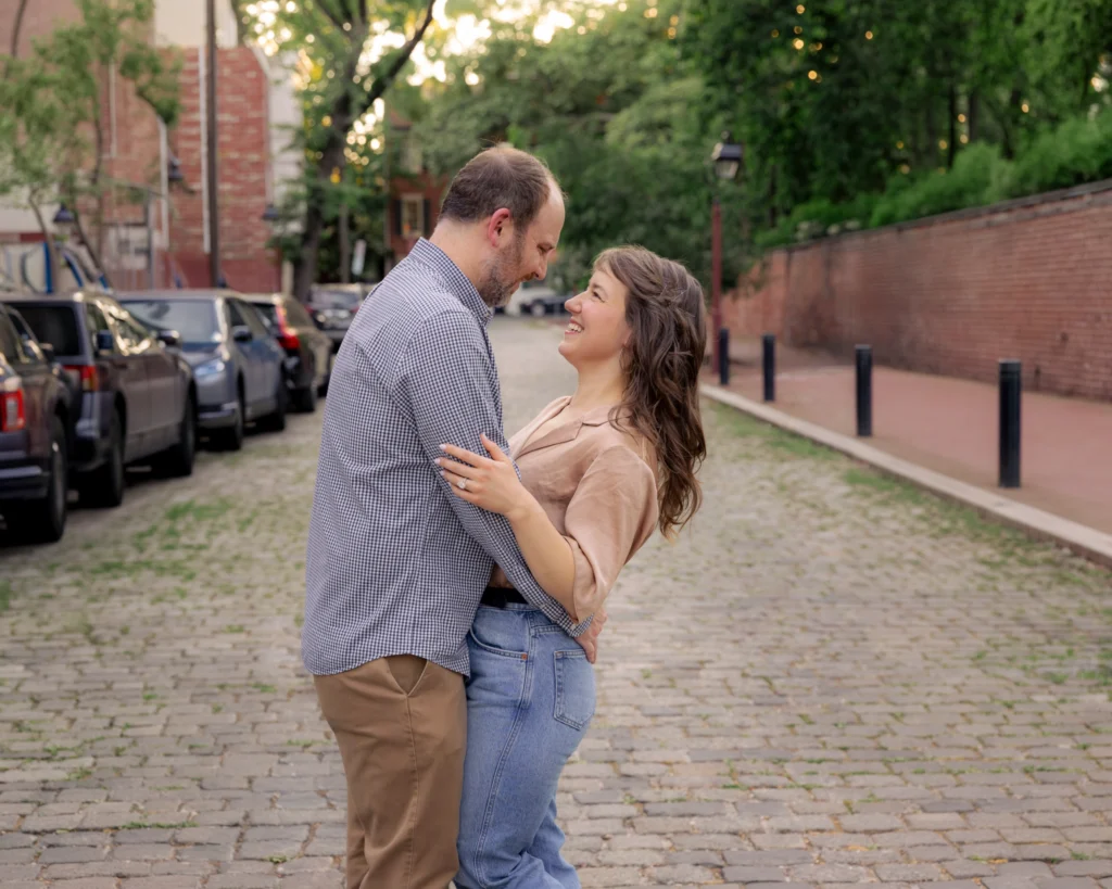 An engaged couple laughing during an engagement session in Old City Philadelphia